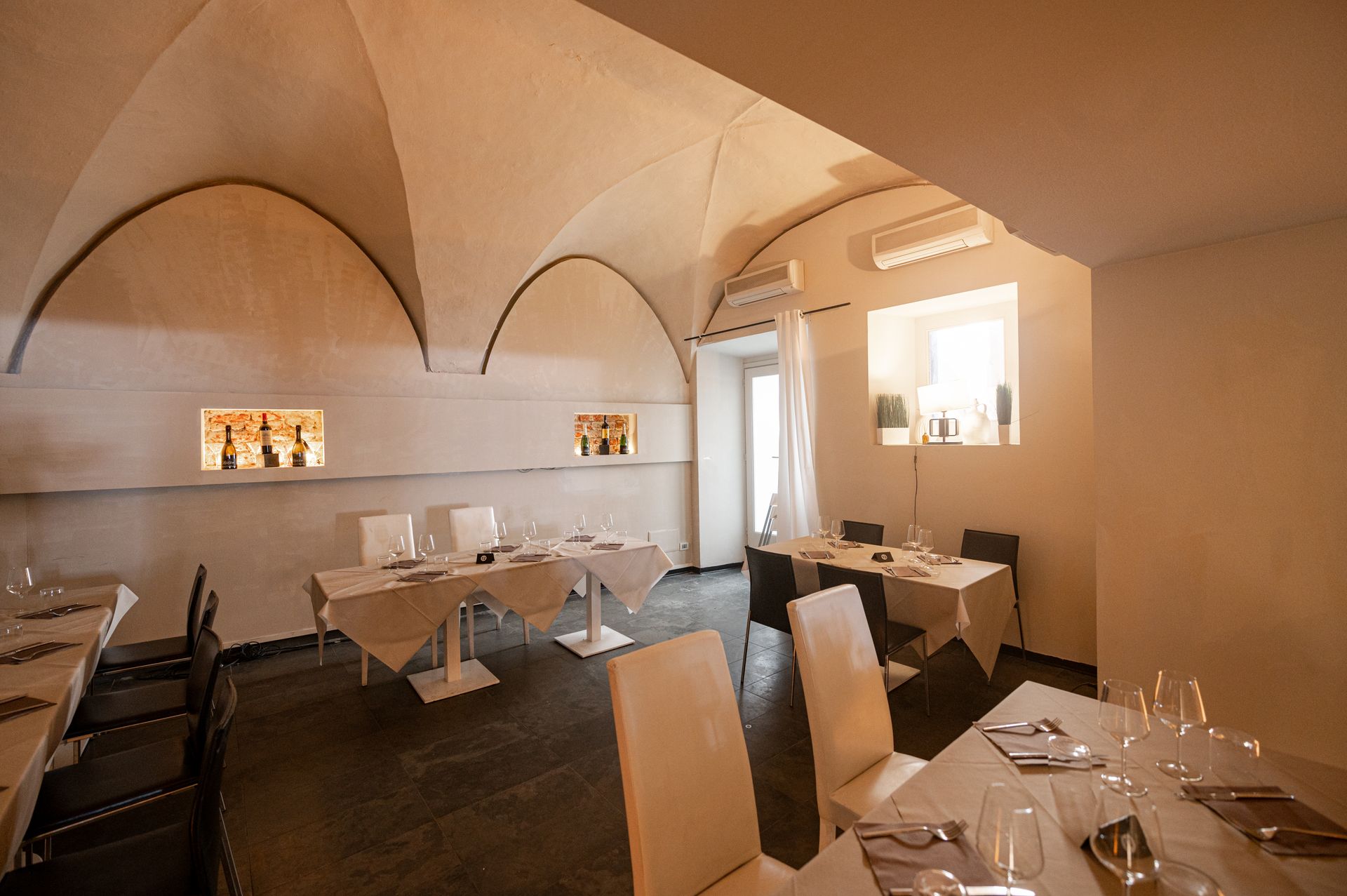 Una sala da pranzo con tavoli e sedie e un soffitto a volta