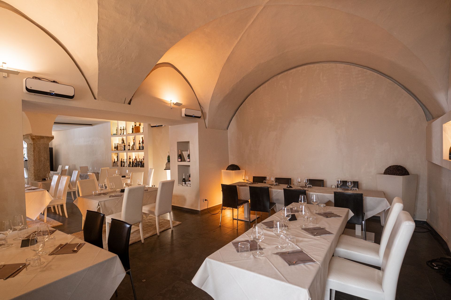 Un ristorante con tavoli e sedie e un soffitto a volta