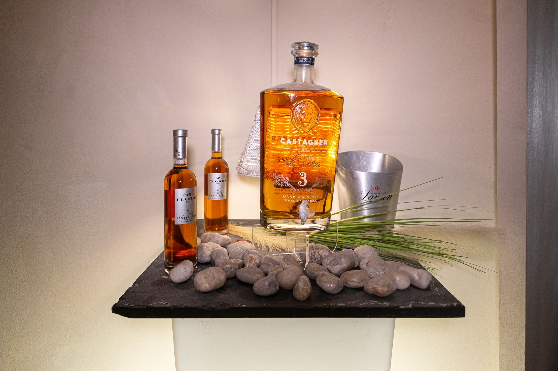 Una bottiglia di alcol è appoggiata su un tavolo accanto a due bottiglie di alcol più piccole.