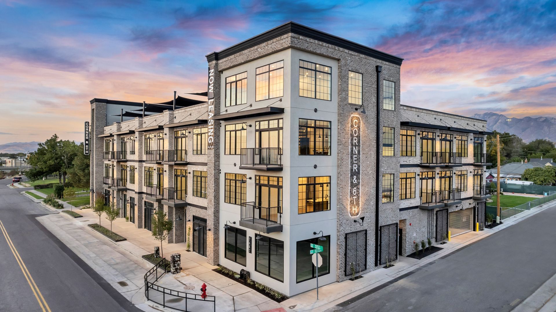 An aerial view of a large apartment building sitting on the corner of a street.