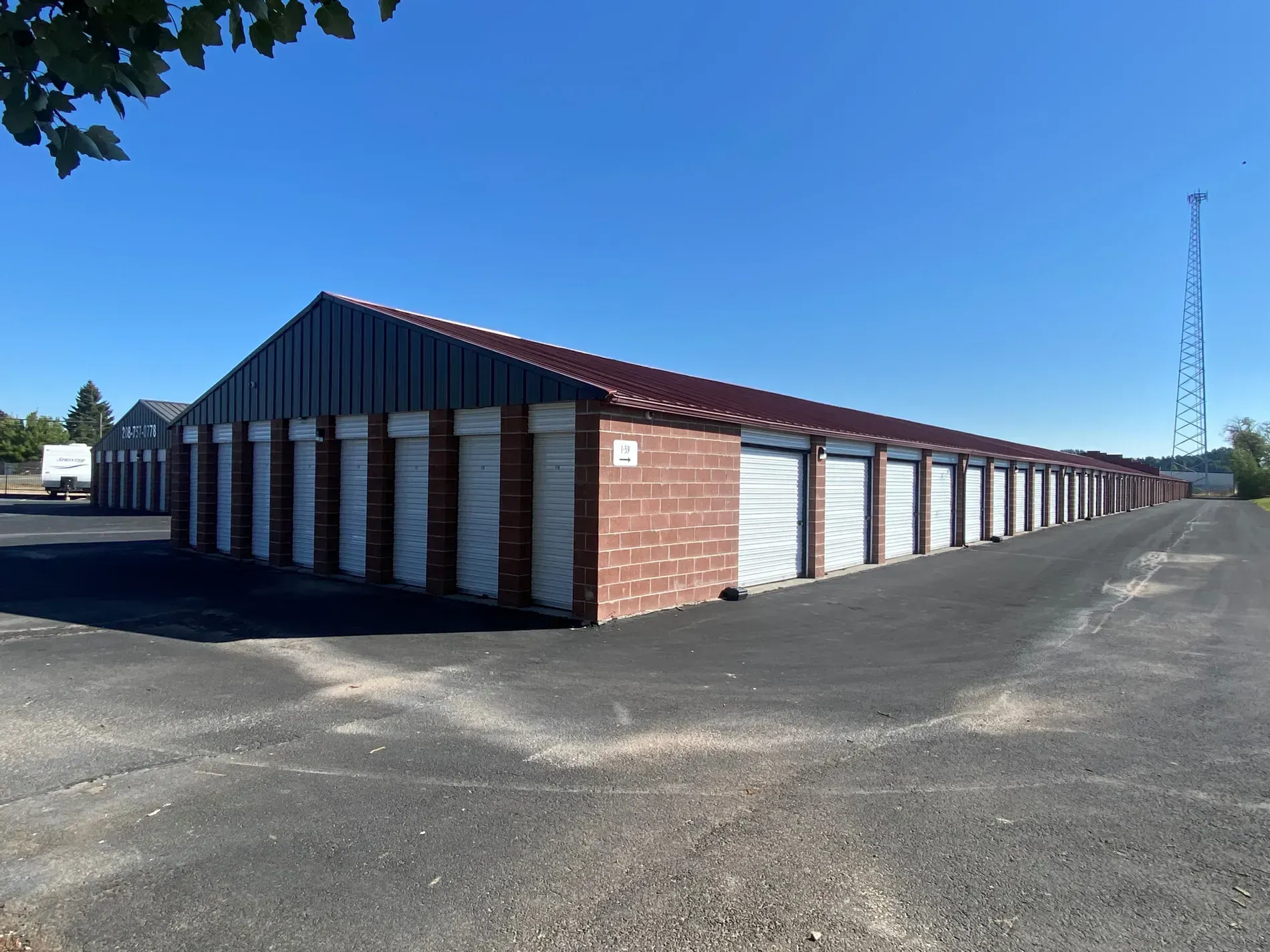 A row of storage units are lined up in a parking lot.