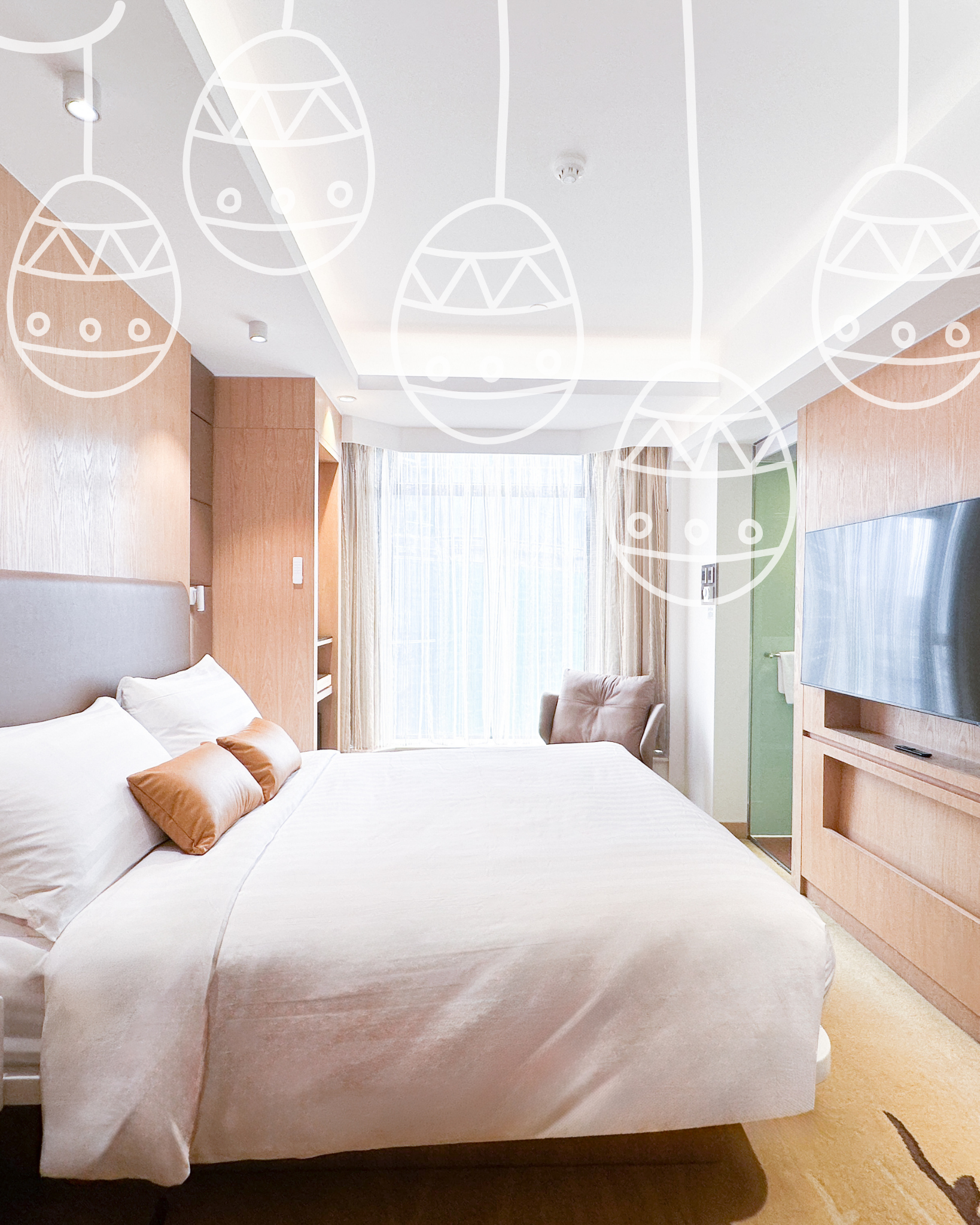 A modern hotel room with two white beds, a gray accent wall, and a desk near a window with curtains.