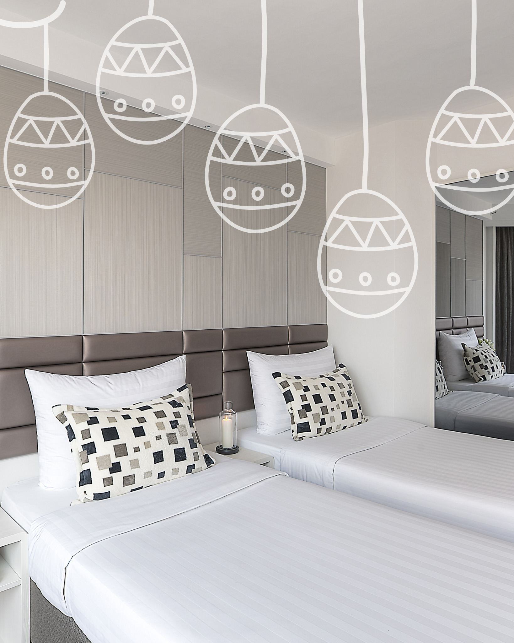 A bedroom with a white-striped bed, patterned throw pillows, a beige paneled headboard, and a dining set by the window.