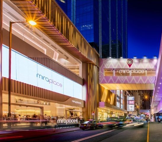 Mira Place shopping mall entrance at night, with bright signage and street traffic.