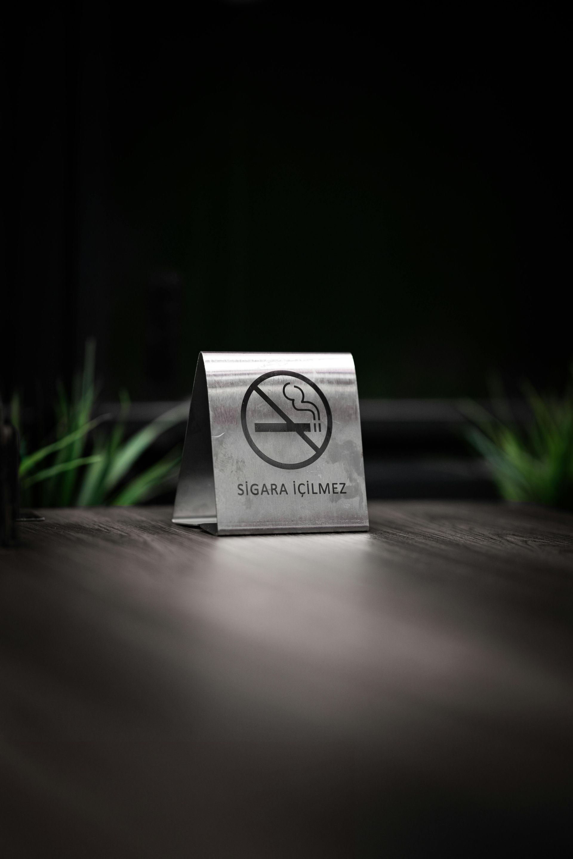 No smoking sign on a dark wood table.