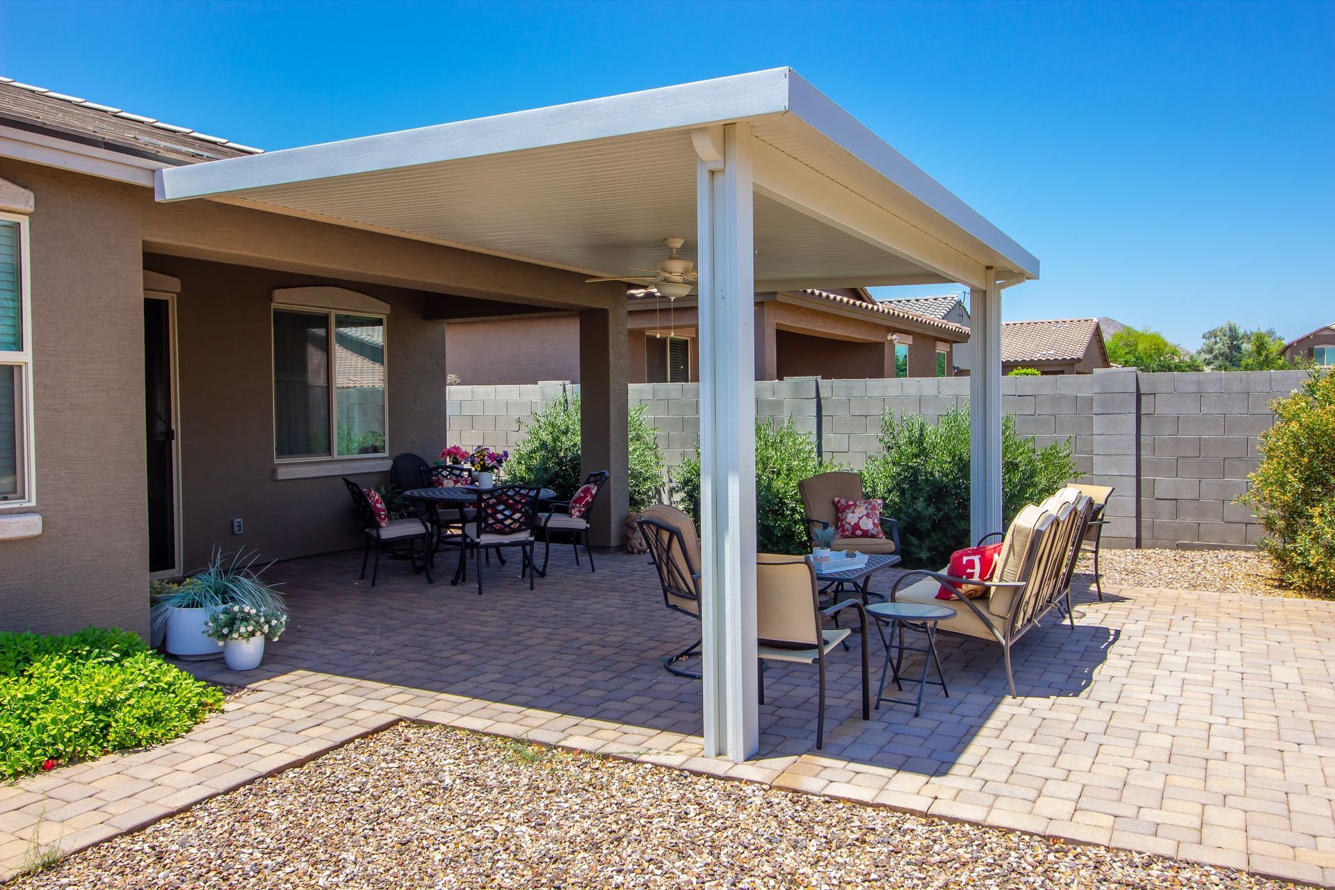 A patio with a table and chairs under a covered patio cover.
