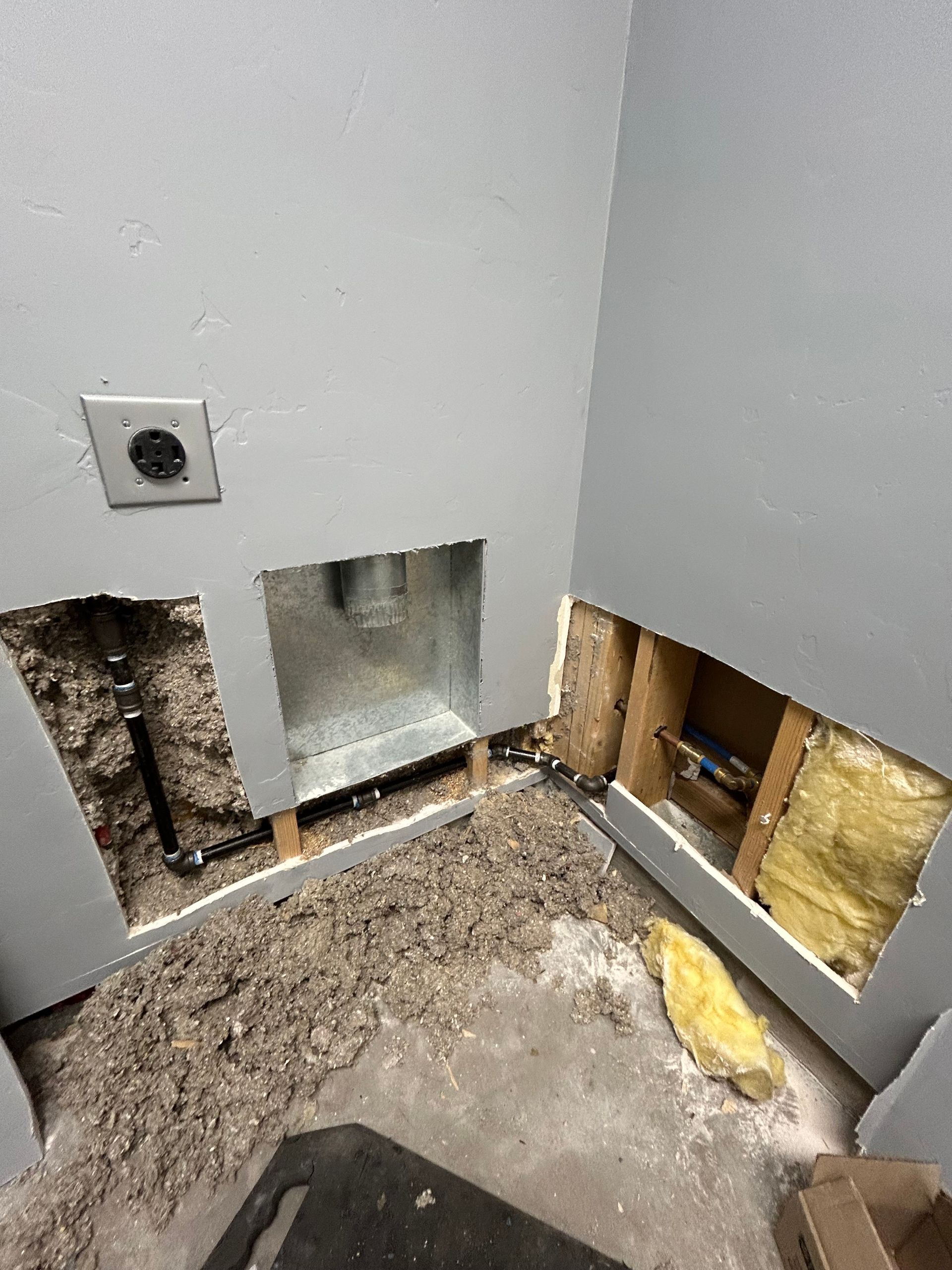 A bathroom with a hole in the wall and a hole in the floor.