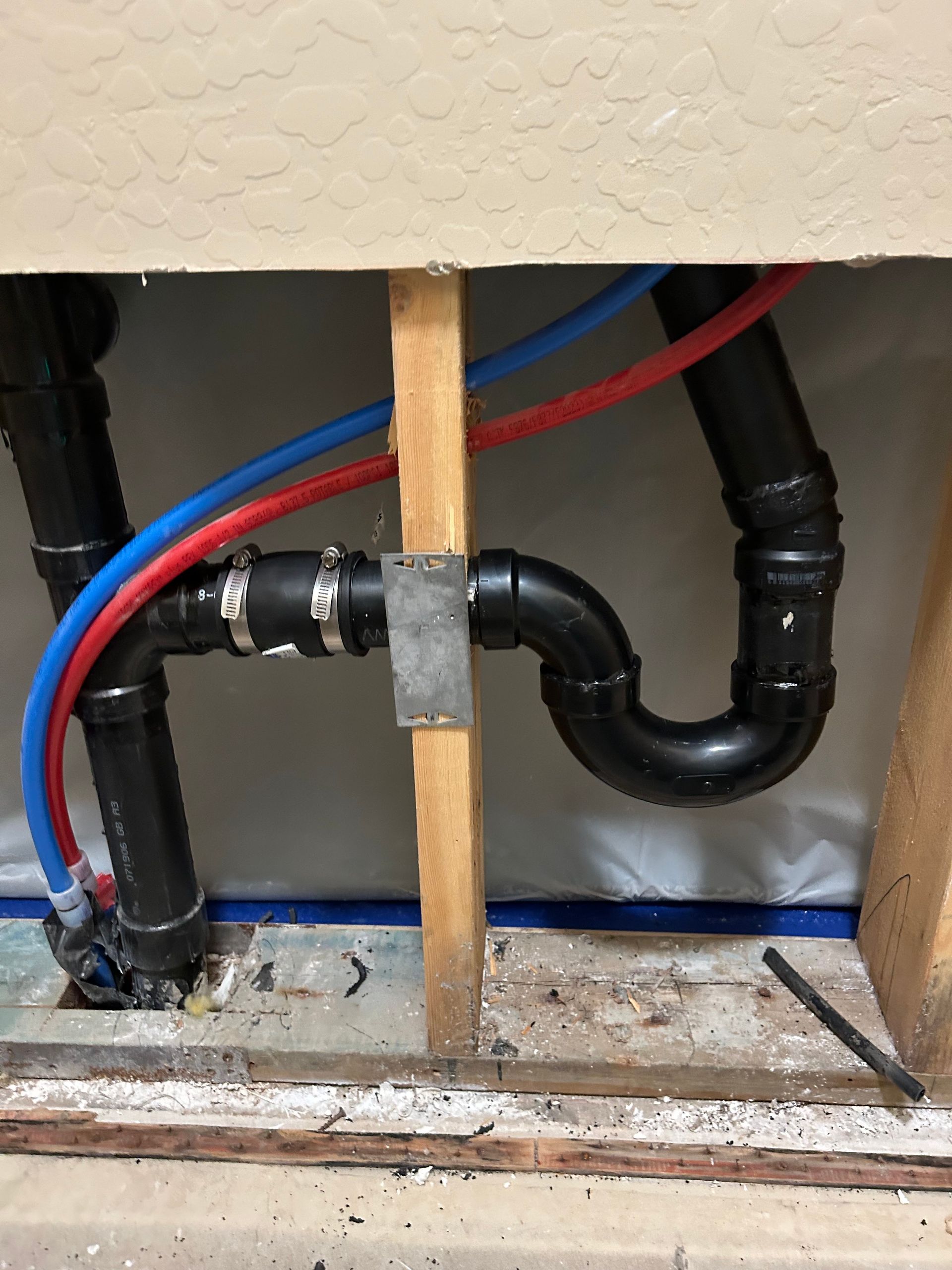 A close up of a pipe with red and blue wires coming out of it