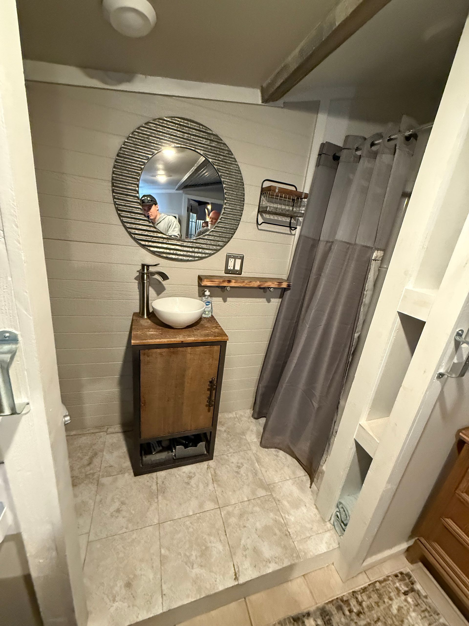 A bathroom with a sink , mirror and shower curtain.