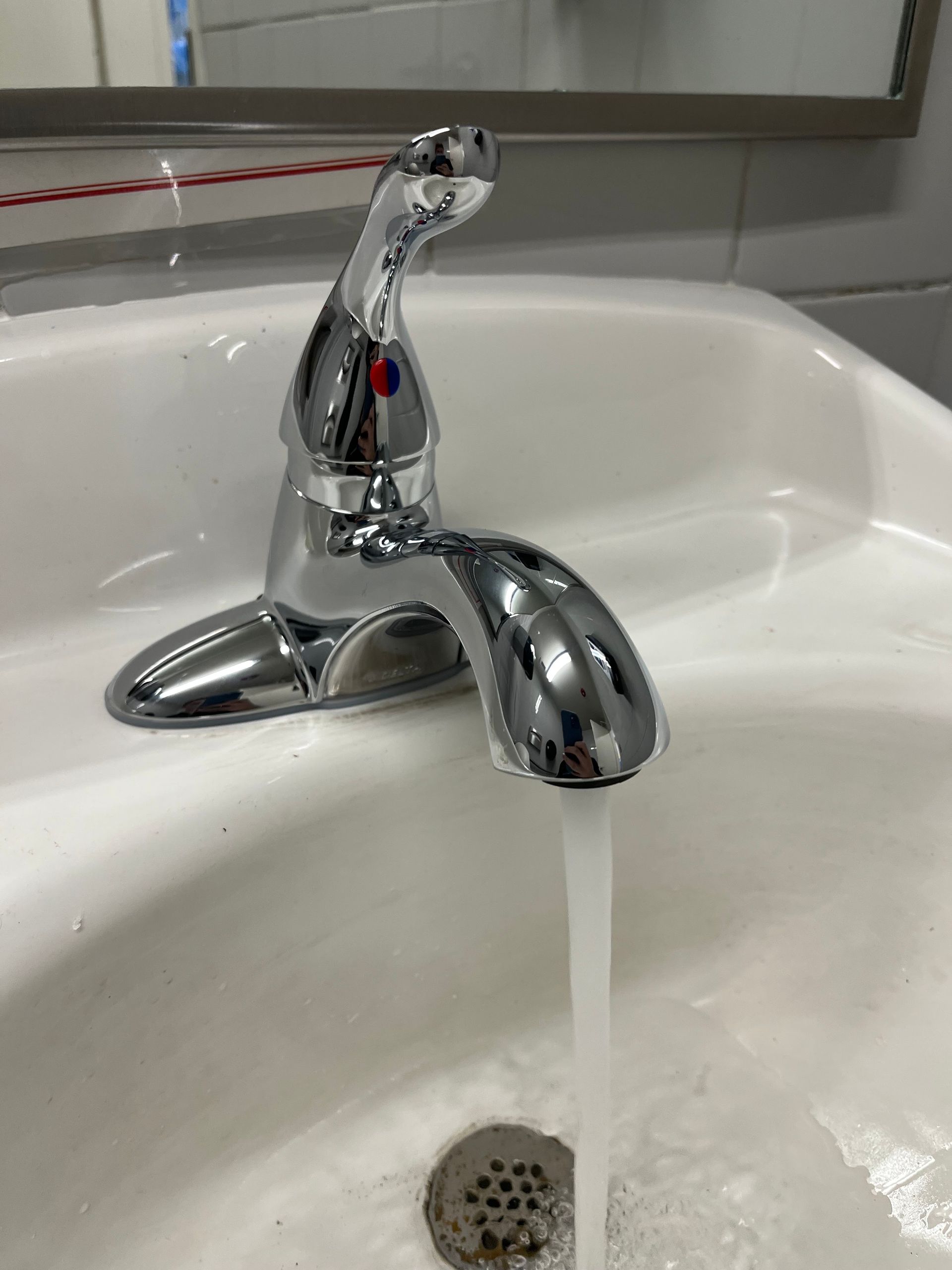 A bathroom sink with water running from the faucet.