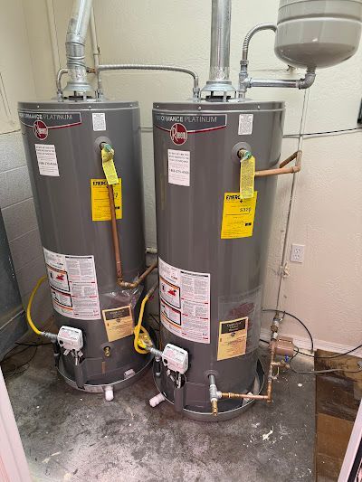 Two water heaters are sitting next to each other in a room.
