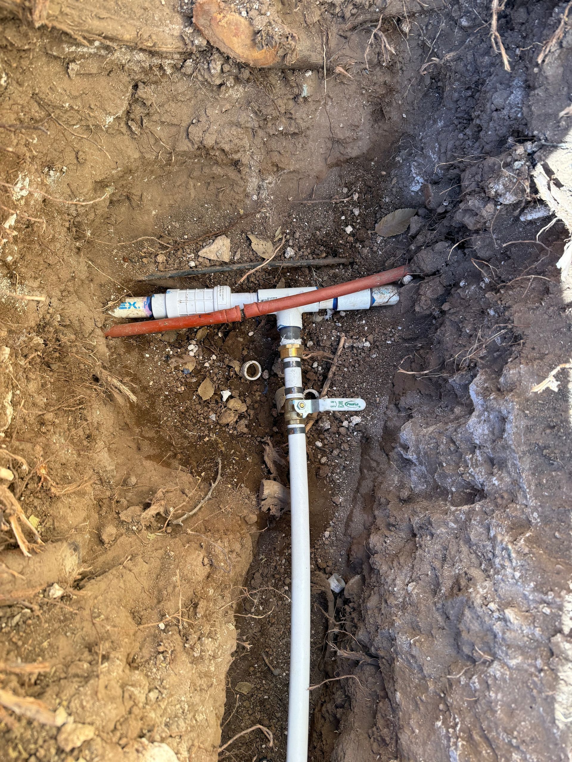 A pipe is sitting in the dirt in the ground.