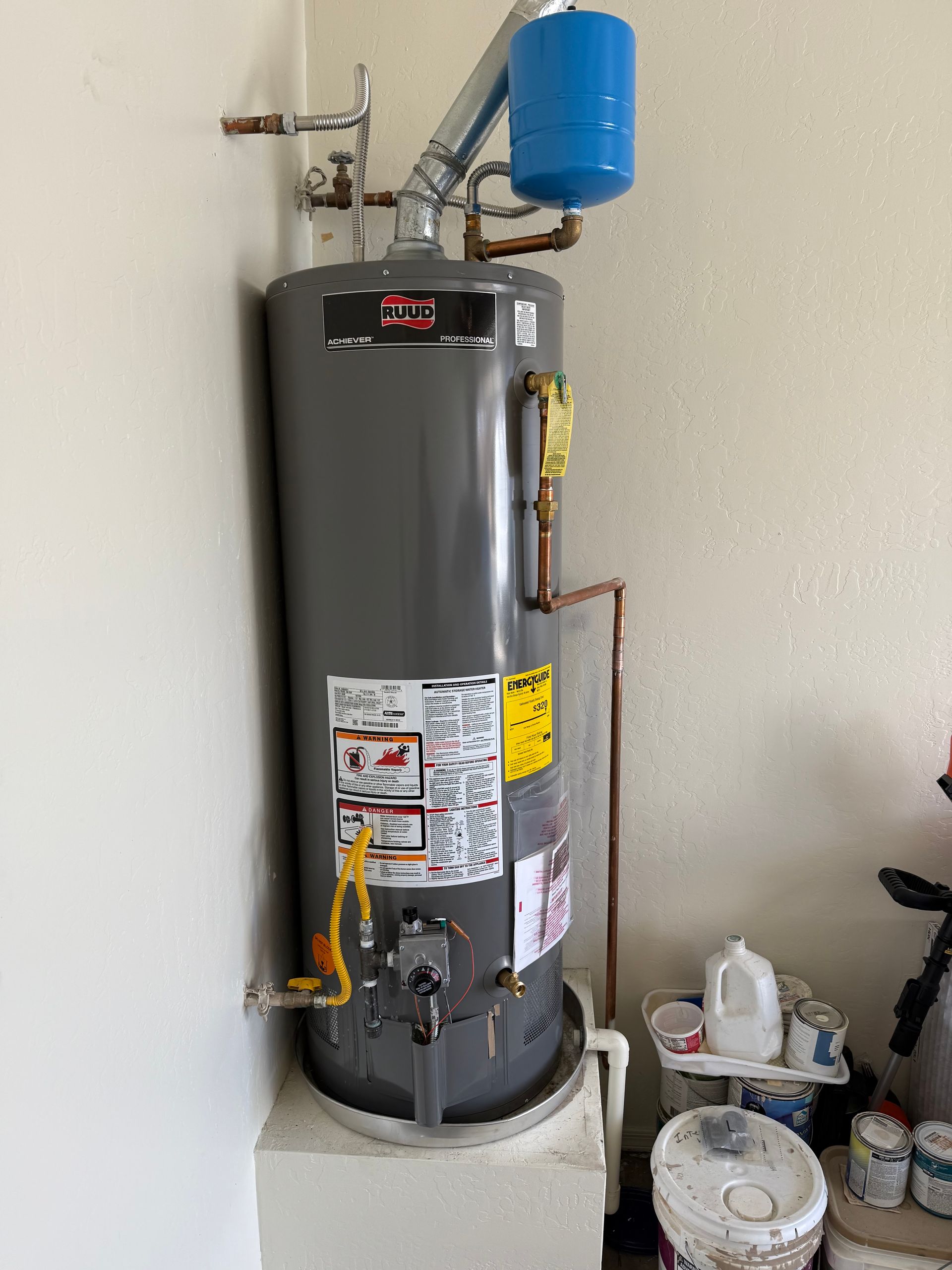 A water heater is sitting in a room next to a wall.