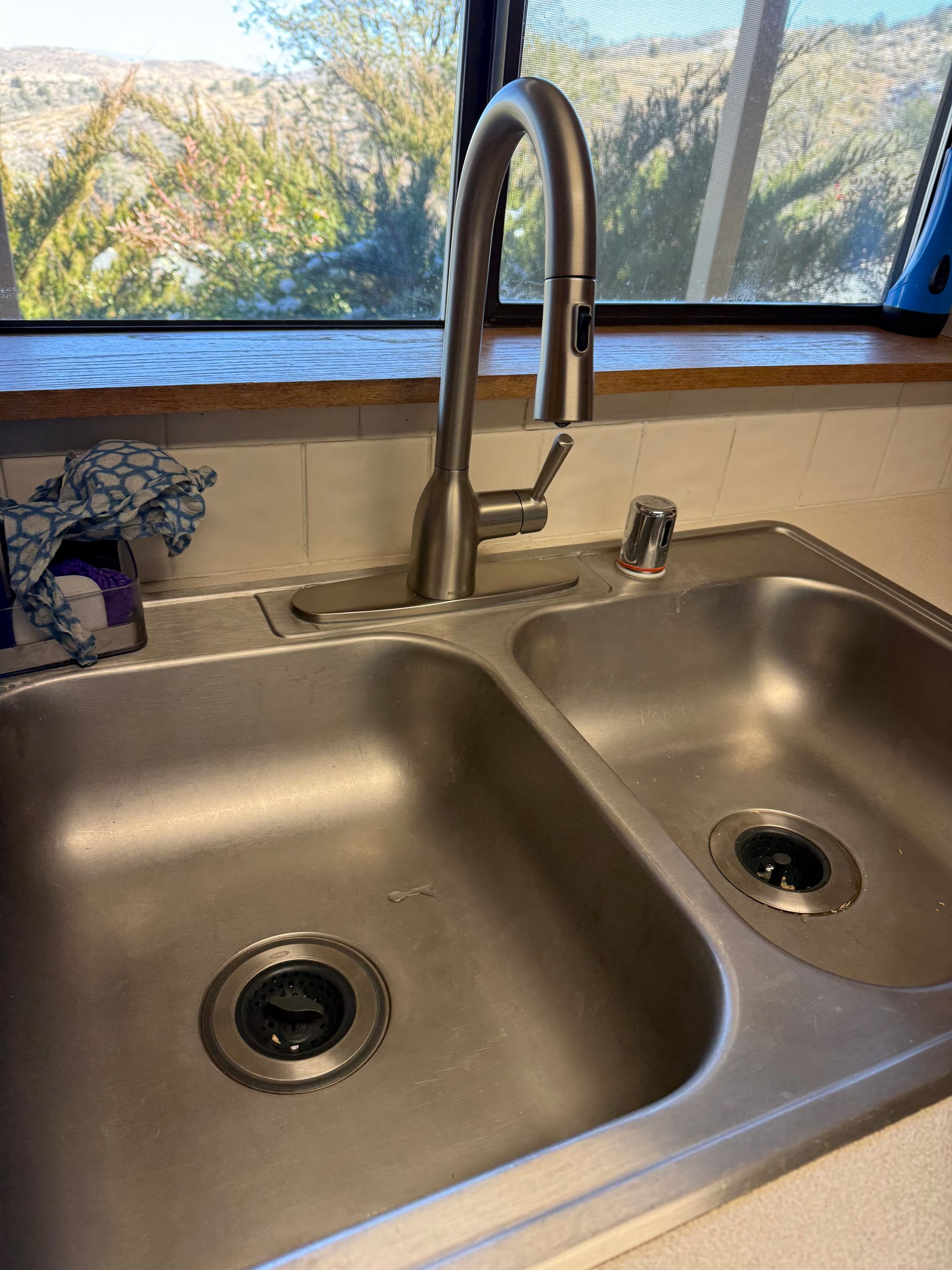 A stainless steel kitchen sink with two sinks and a faucet.