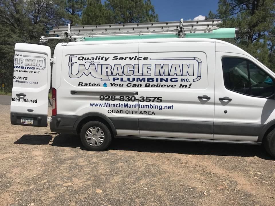 A white van for miracle man plumbing is parked on the side of the road.