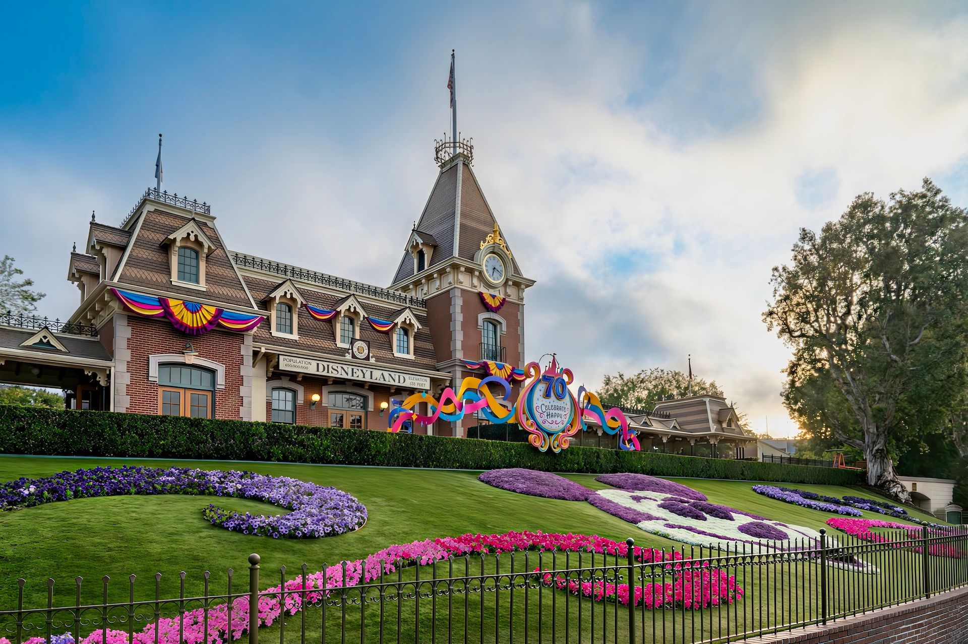 Disneyland Railroad station with colorful floral display and decorations.