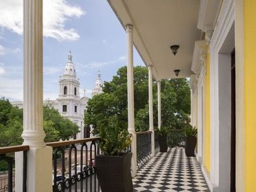 A balcony with a view of a church in the background