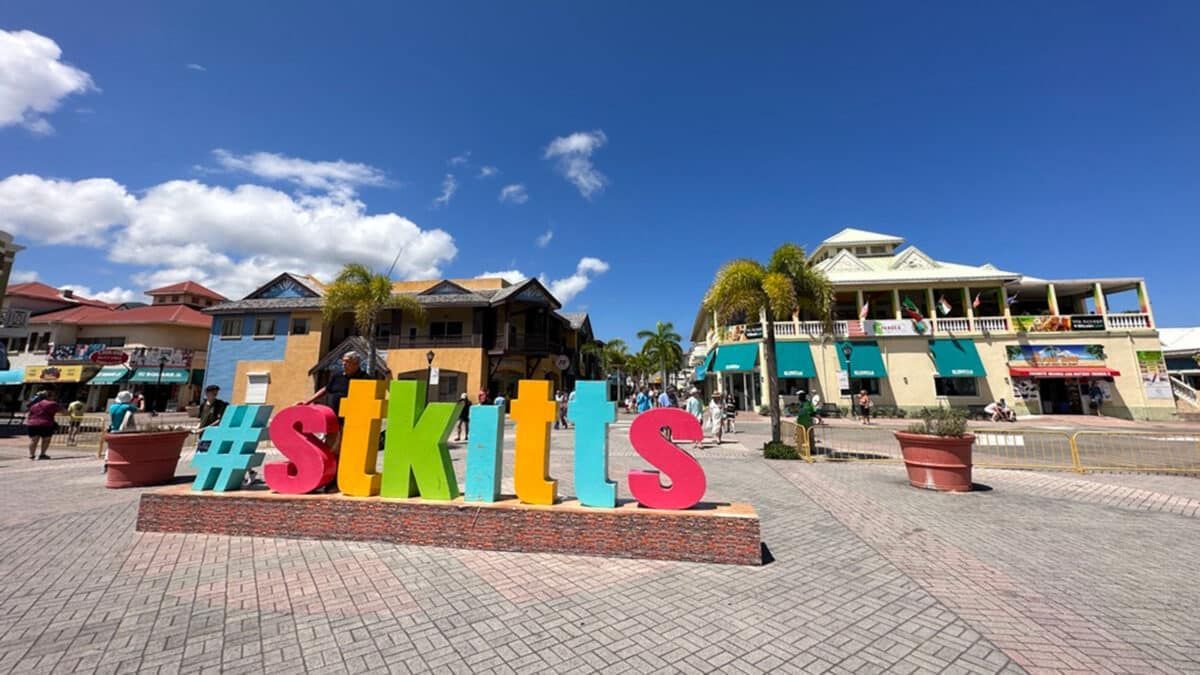 Colorful “#skittles” sign in a sunny plaza with shops and palm trees under a blue sky
