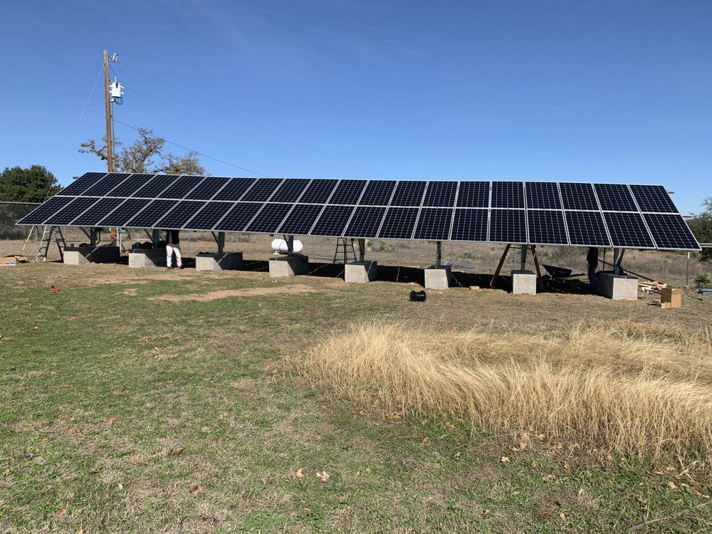A row of solar panels are sitting in a field.