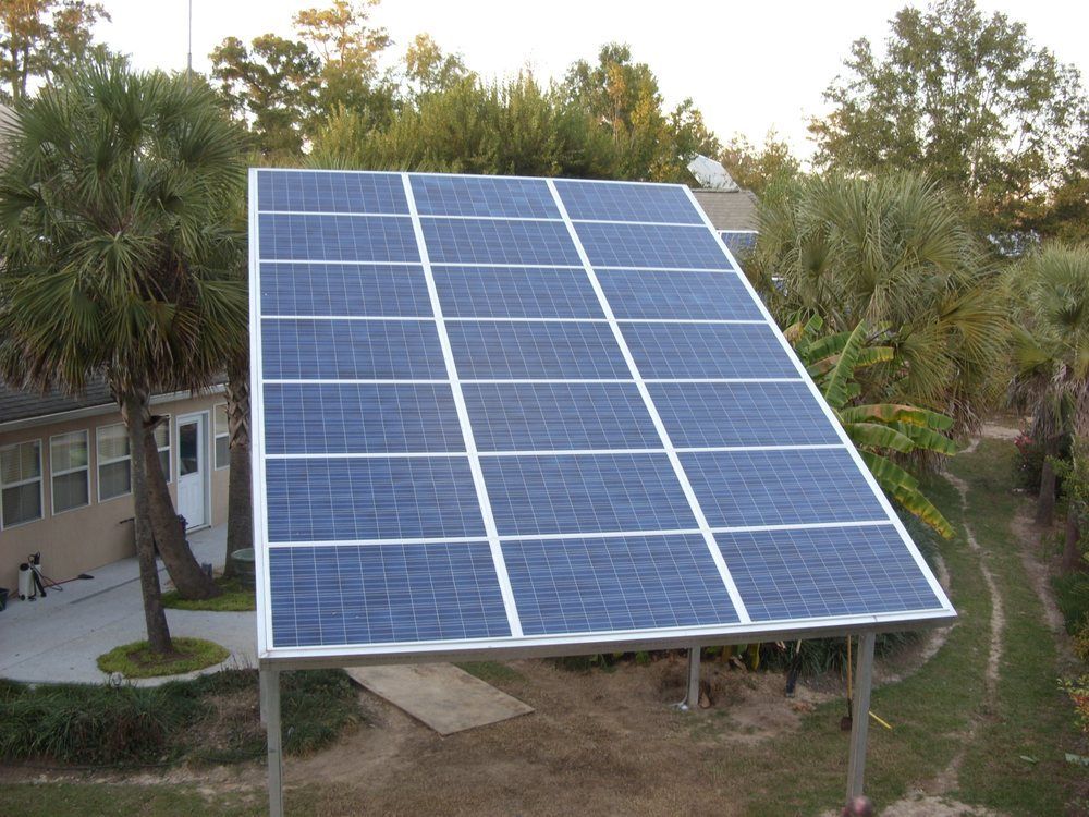A row of solar panels are sitting in front of a house