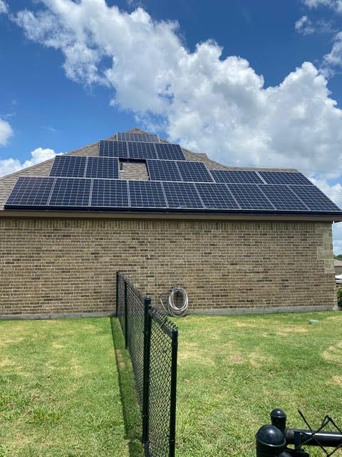 A brick house with a lot of solar panels on the roof.