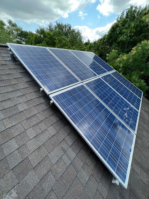 A row of solar panels sitting on top of a roof