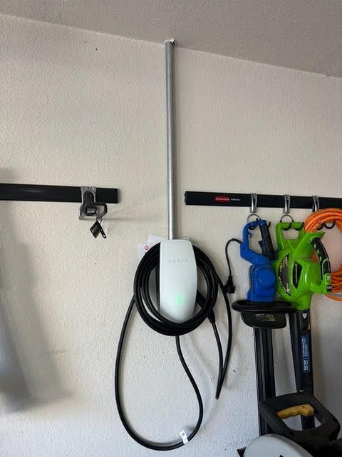 A tesla charging station is hanging on a wall
