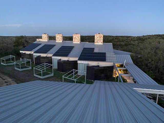An aerial view of a house with solar panels on the roof.