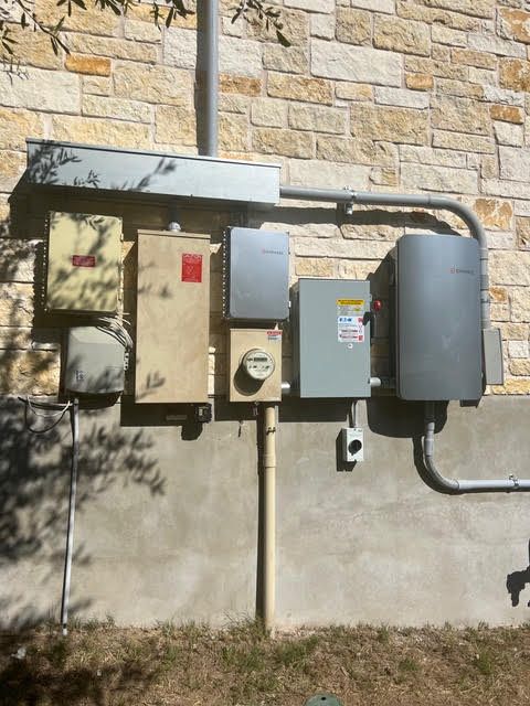 A brick wall with a bunch of electrical boxes on it