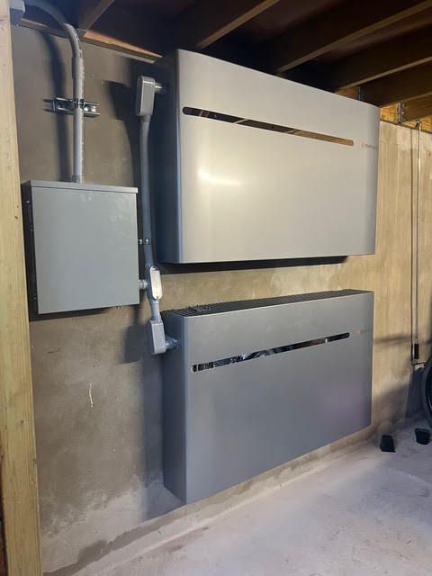 Two gray boxes are hanging on a wall in a room.