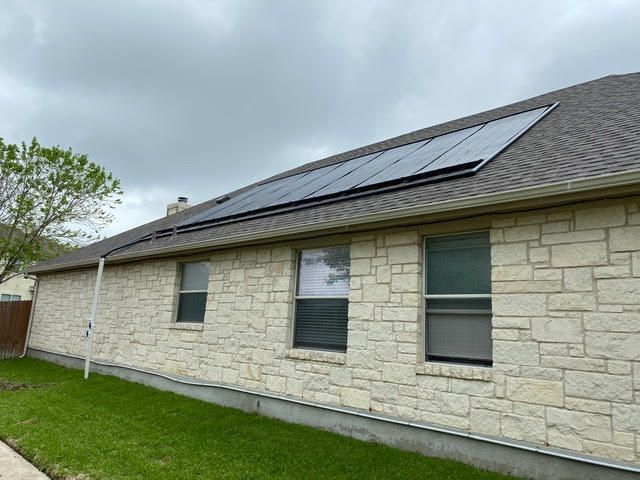 A house with a lot of windows and solar panels on the roof.