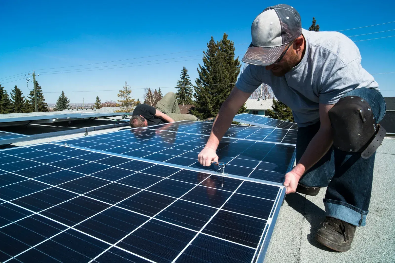 A man is installing solar panels on a roof