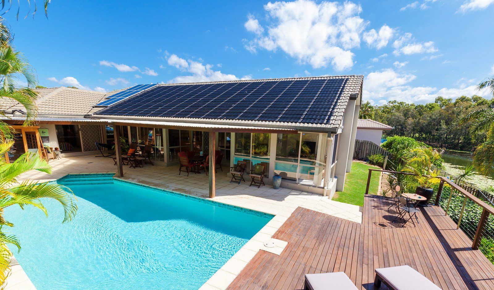 A house with a swimming pool and solar panels on the roof.