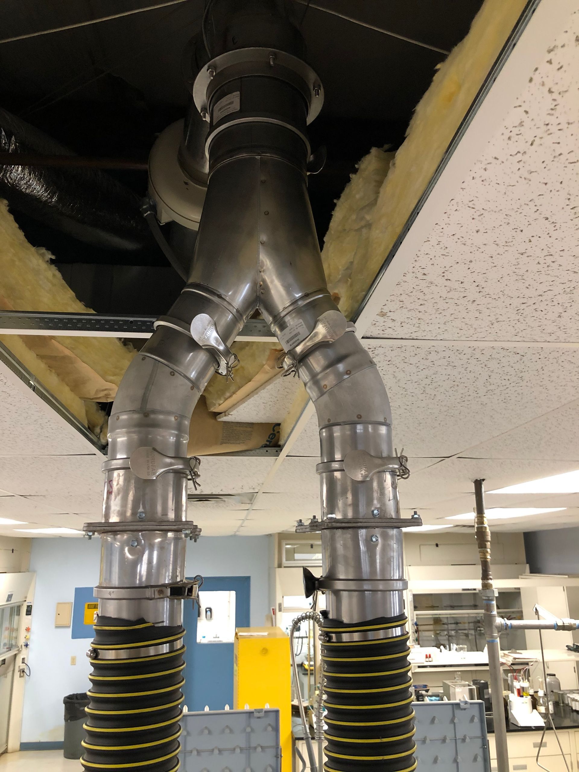 A man is fixing an air conditioner with a multimeter.