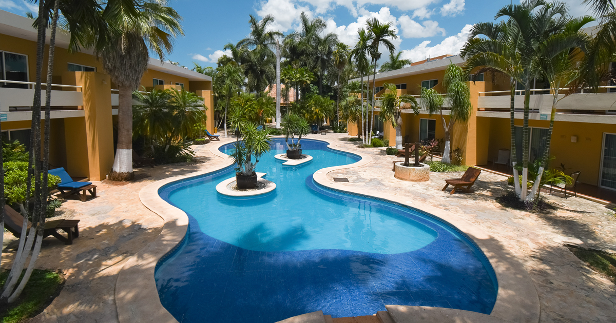 Una gran piscina rodeada de edificios y palmeras en Tecnohotel Beach