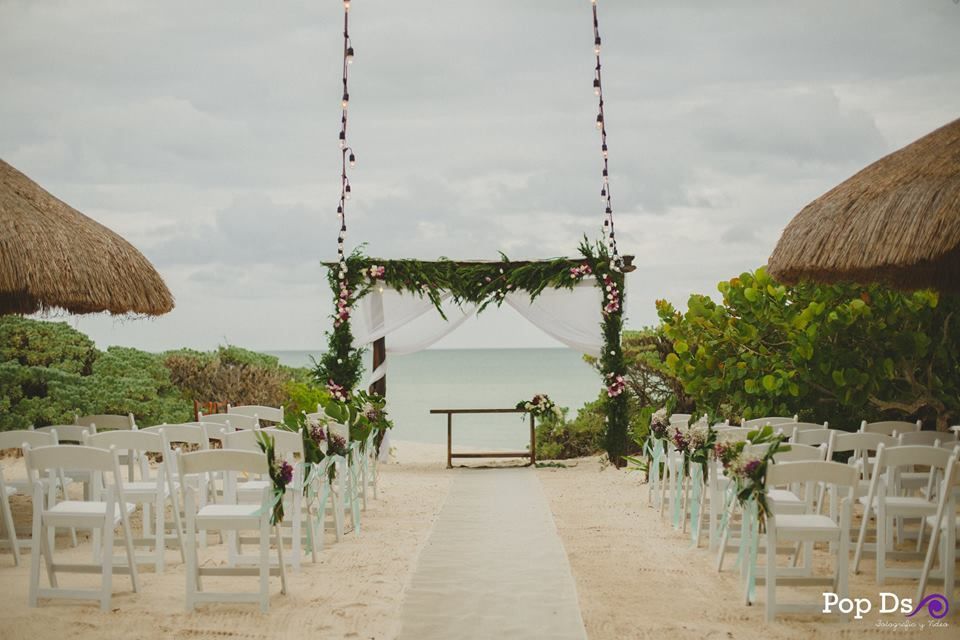Se está celebrando una ceremonia de boda en la playa.