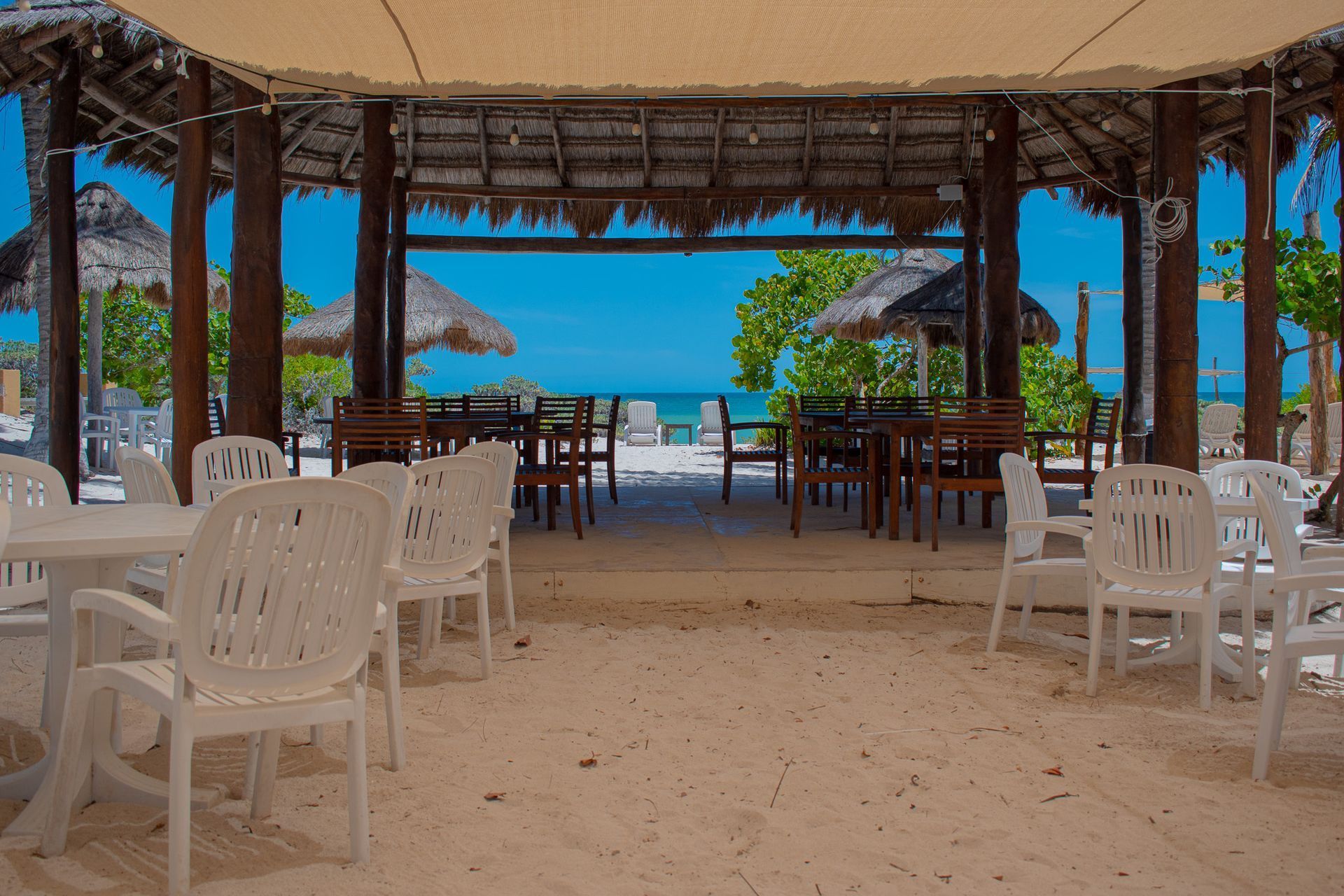 Mesas y sillas en la playa bajo una sombrilla en Tecnohotel Beach