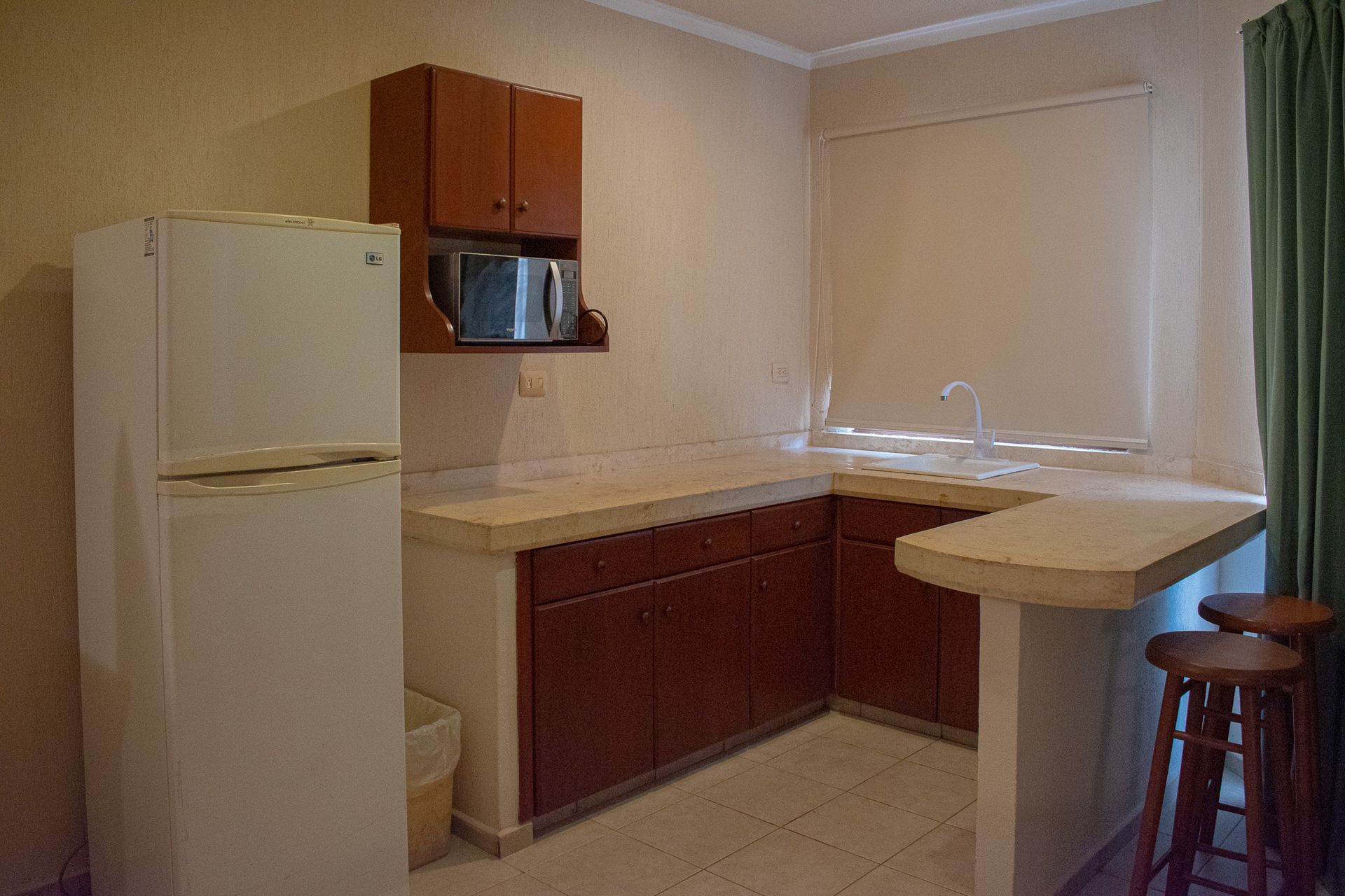 Una cocina con frigorífico, fregadero y microondas en Tecnohotel Beach.