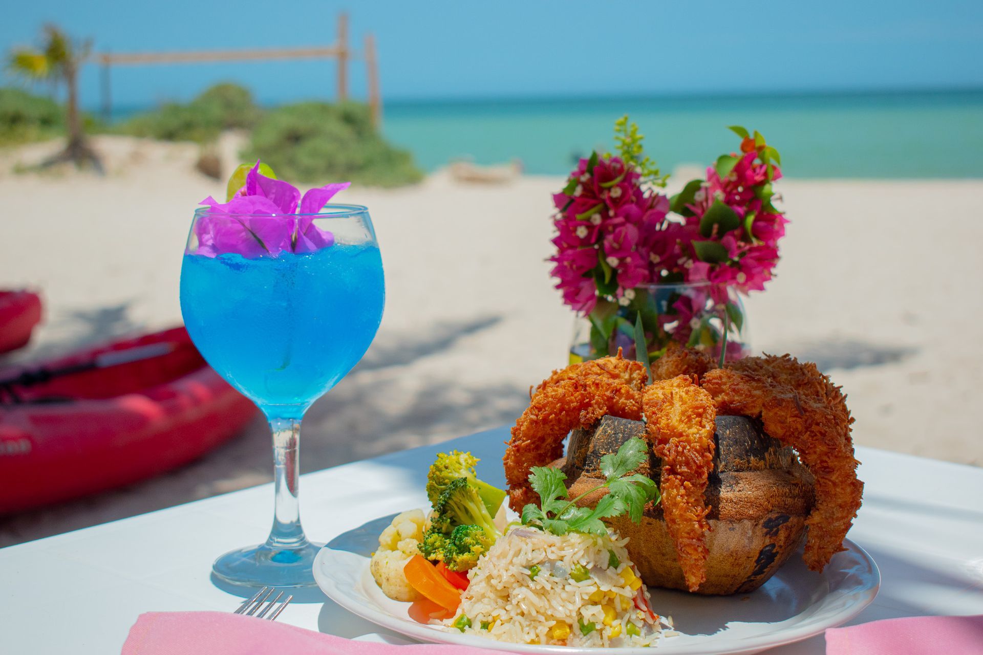 Un plato de comida y una bebida azul en Tecnohotel Beach