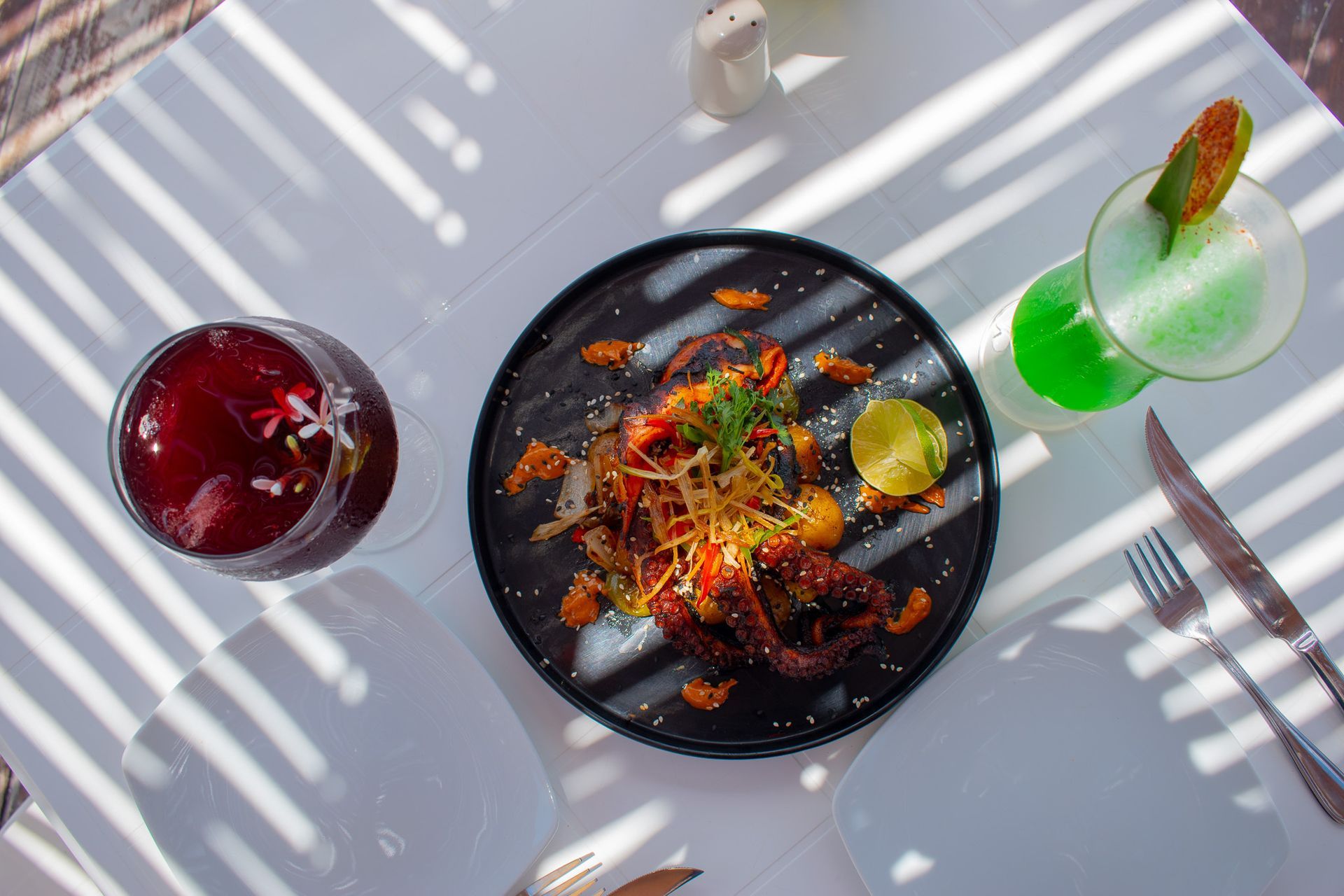 Un plato de comida y una copa de vino en una mesa Tecnohotel Beach