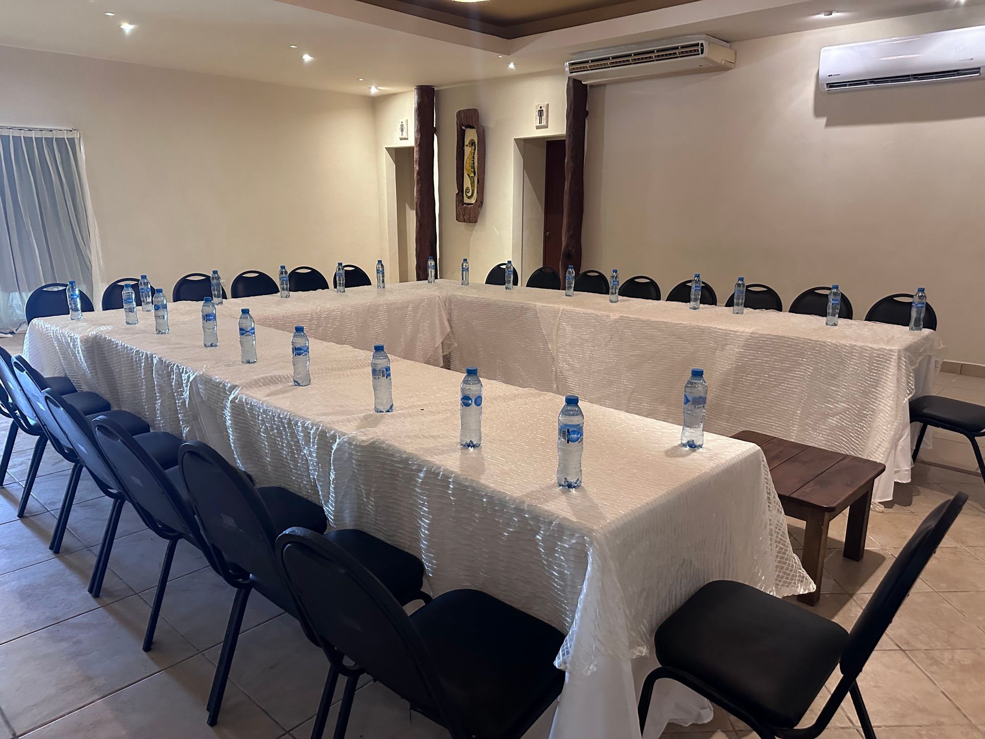 Una sala de conferencias con una mesa larga y sillas preparadas para una reunión en Tecnohotel Beach.