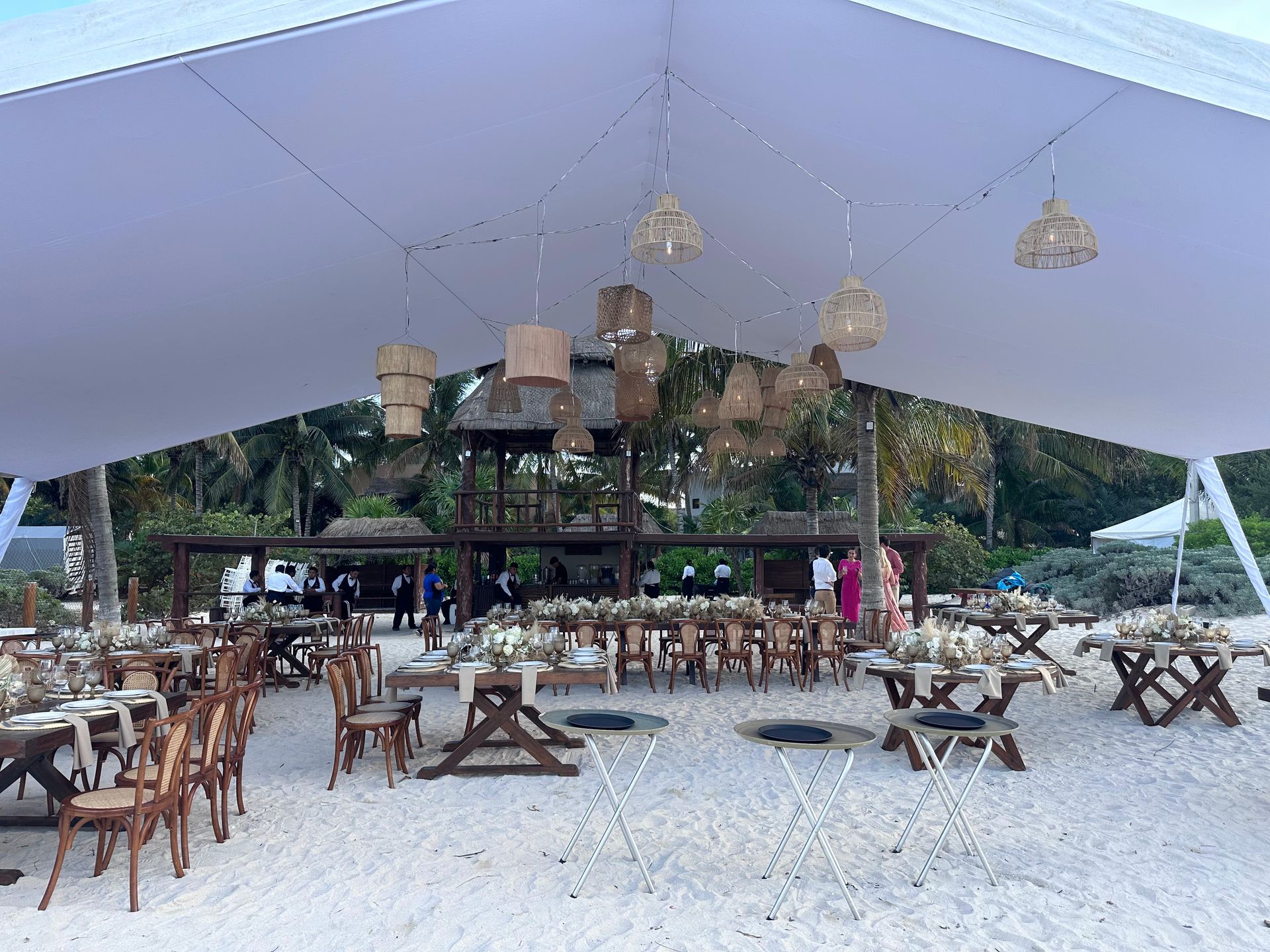 Una gran carpa blanca se encuentra sobre una playa de arena.