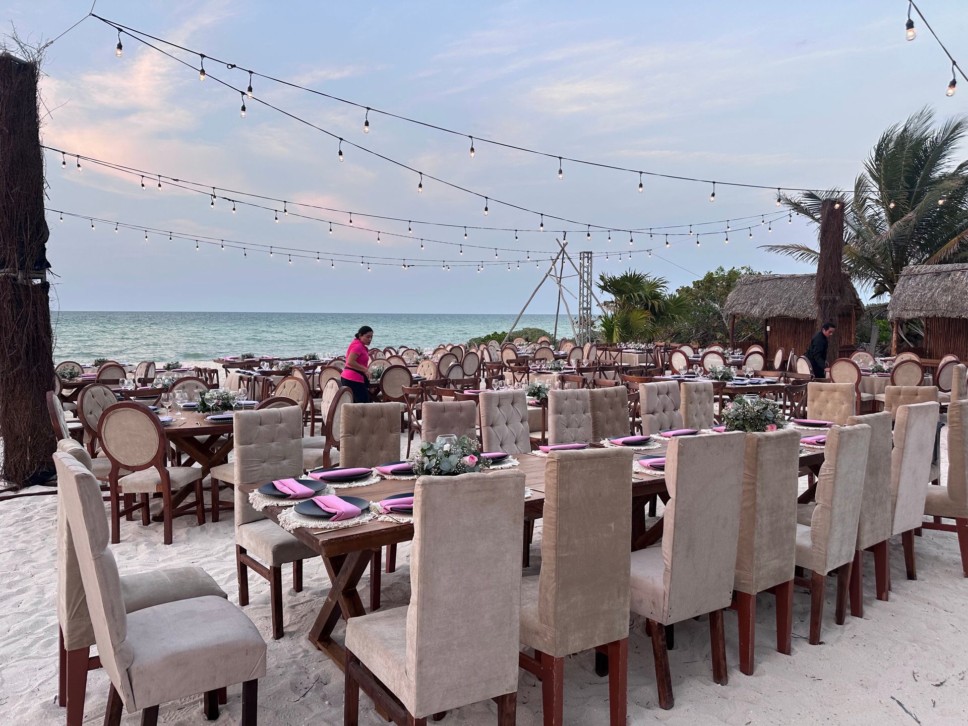 Una mesa larga y sillas están instaladas en la playa.