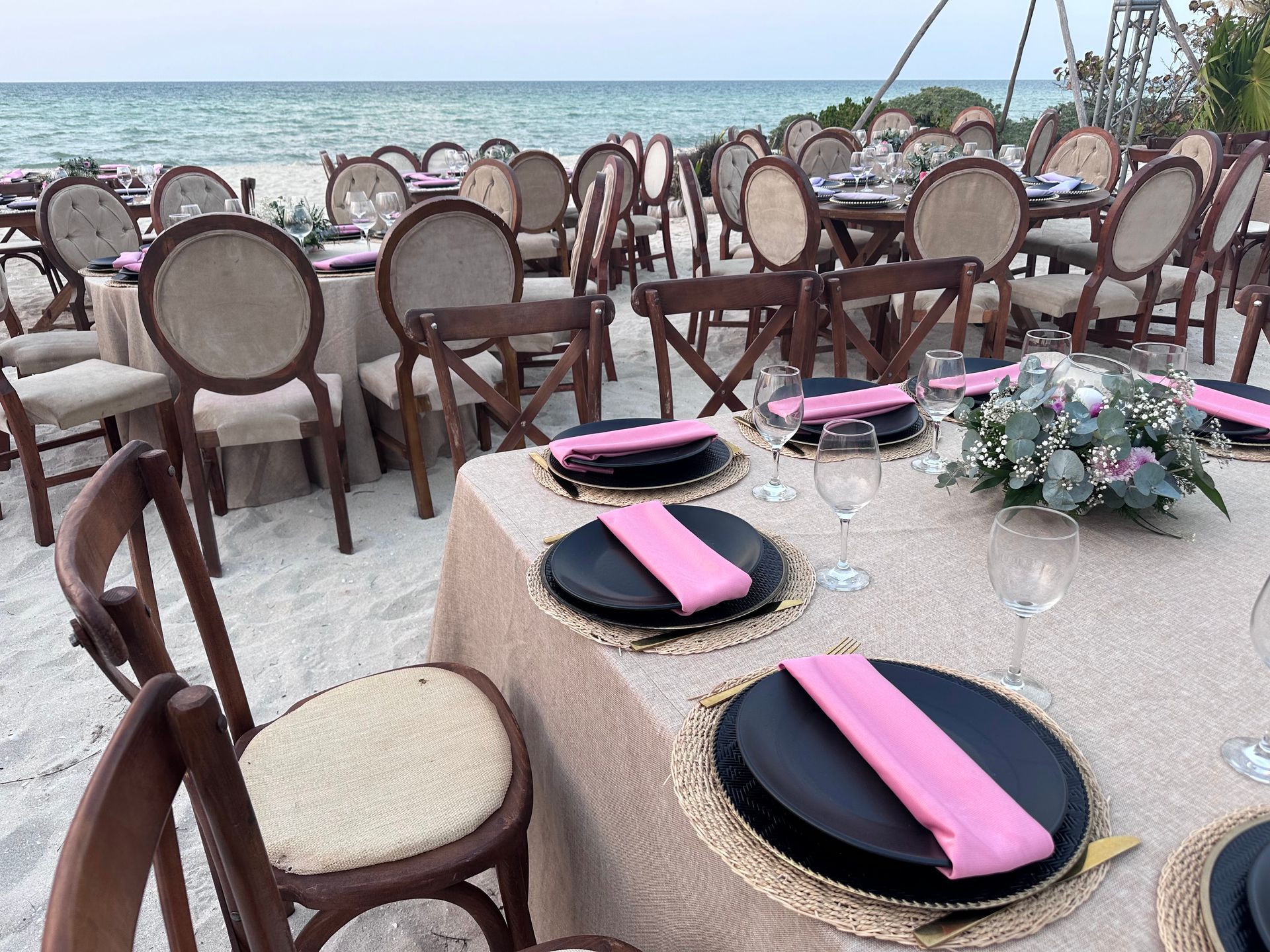 Una mesa preparada para una recepción de boda en la playa.