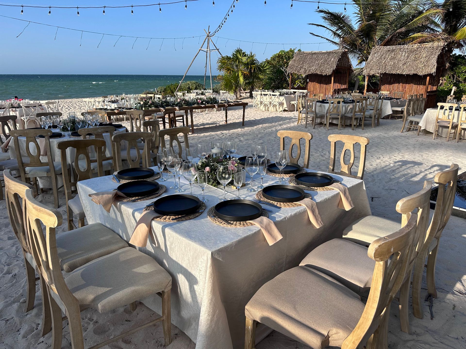 Una mesa y sillas están instaladas en la playa para una recepción de boda.