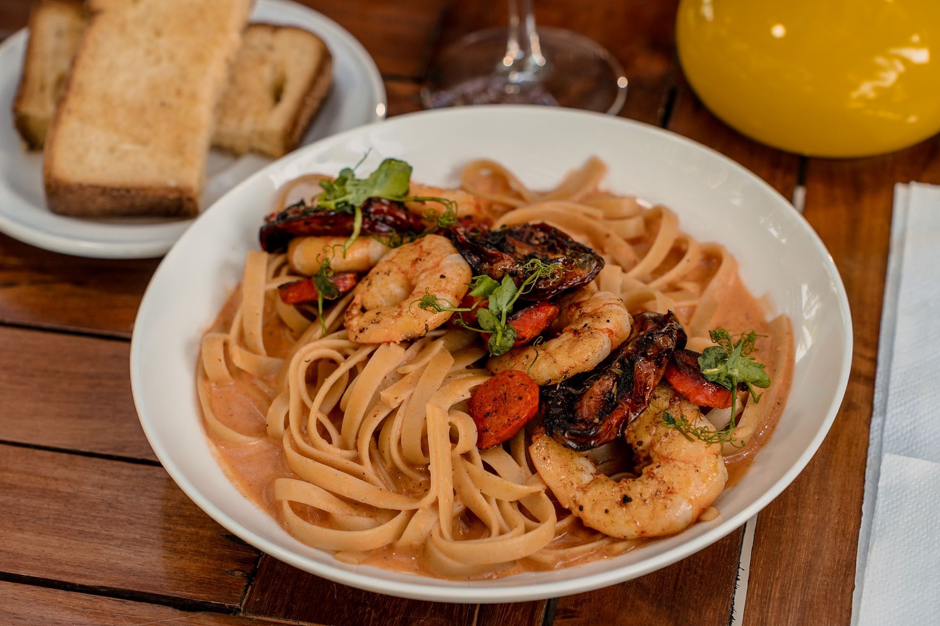 Un plato de comida y una bebida en una mesa en la playa Tecnohotel Beach