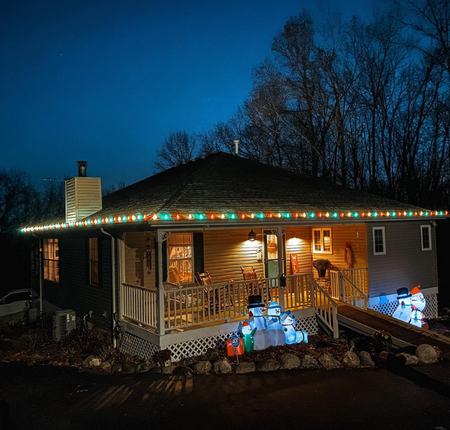 A house with christmas lights and snowmen on the porch