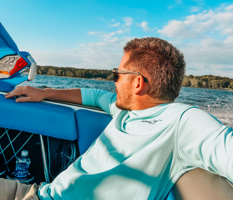 A man wearing sunglasses is sitting on a boat
