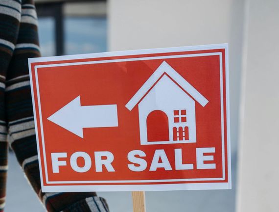 A person is holding a sign that says for sale