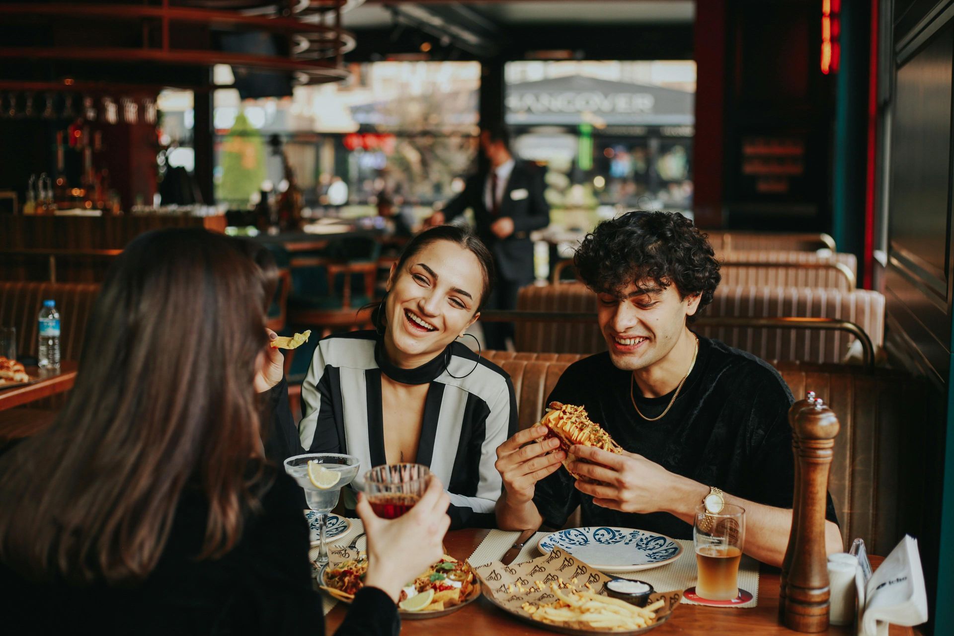A group of people are sitting at a table in a restaurant eating food.